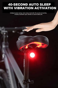 Black round bike light with red lens and hook mount